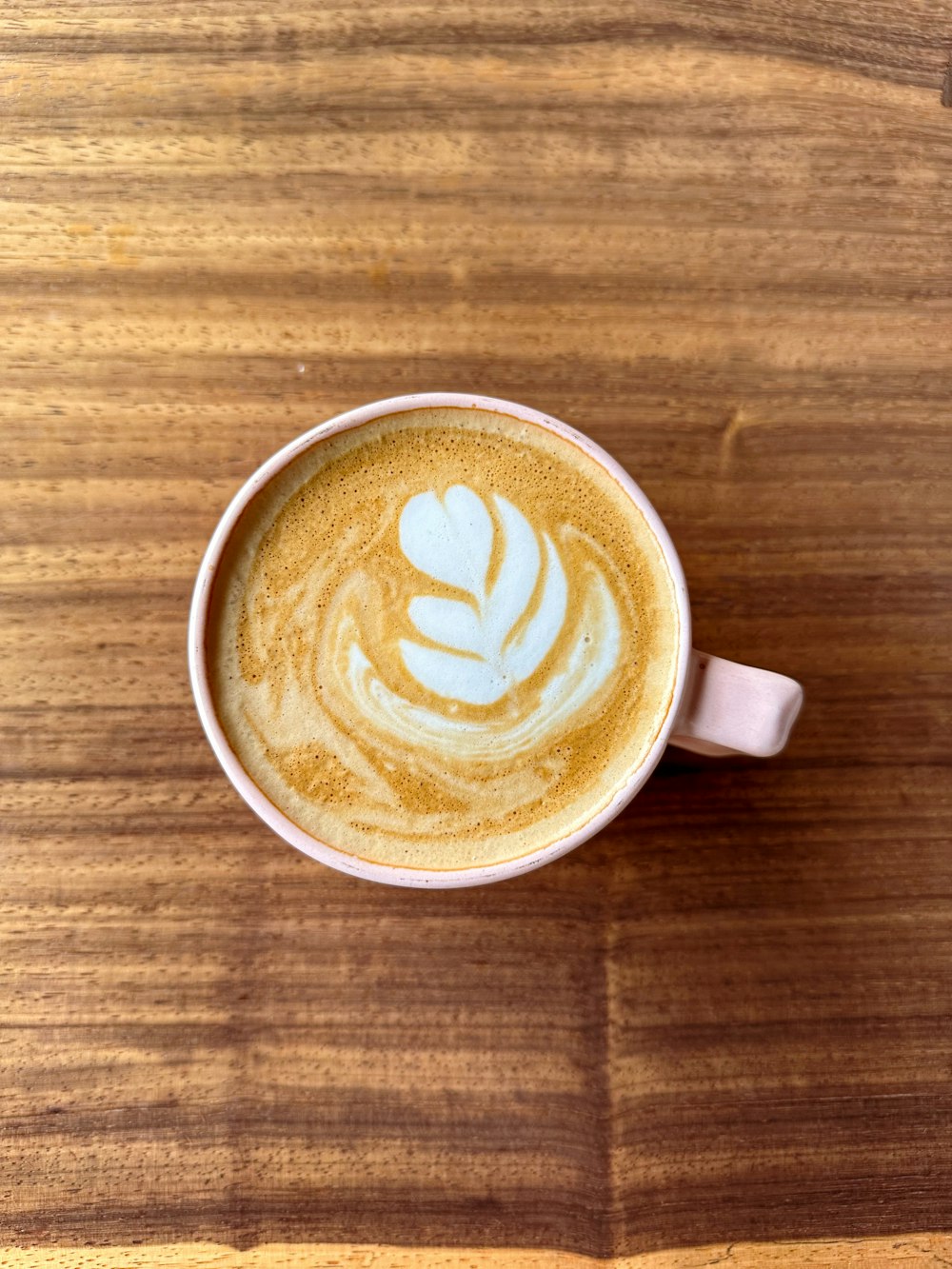 a cup of coffee on a wooden table