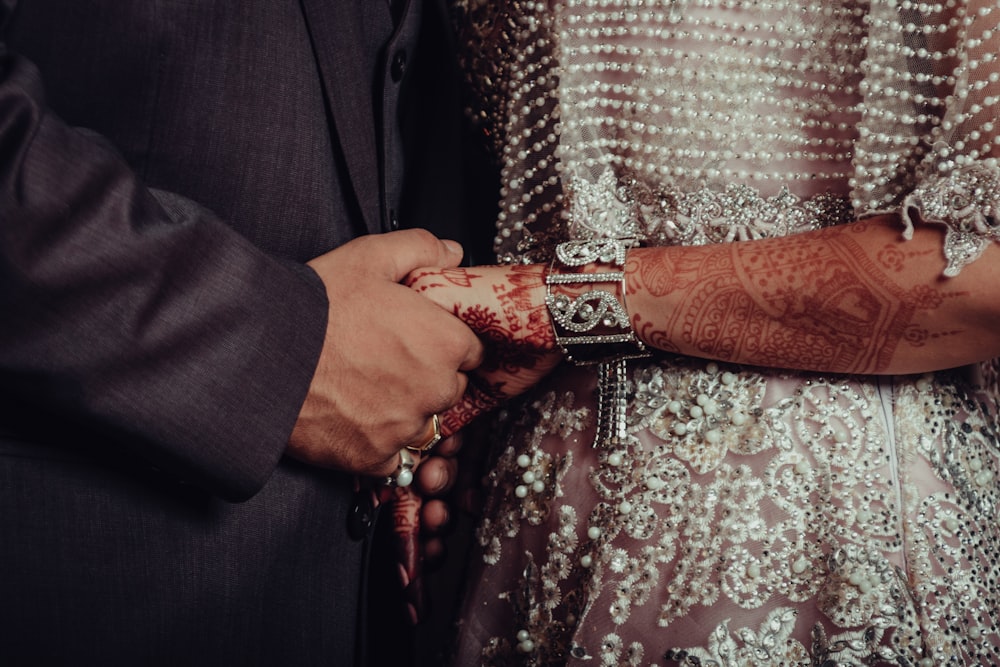 a man and a woman holding hands with henna on their hands