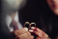 a close up of a person holding two wedding rings