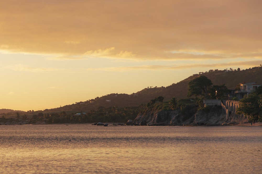 a large body of water with a hill in the background