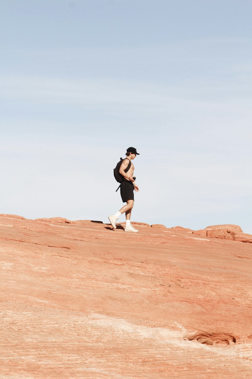 a man running up a hill in the desert