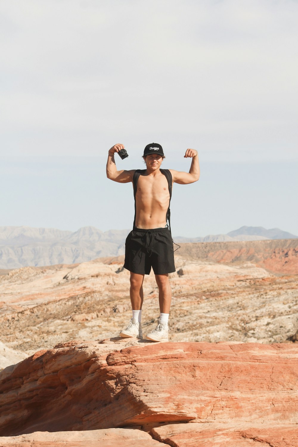 a shirtless man standing on top of a rock