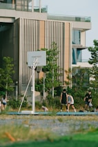 A group of friends laughing and playing basketball on an outdoor court.