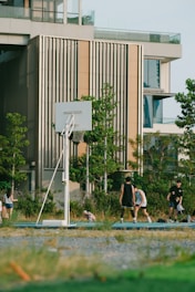 A diverse group of people playing basketball together outdoors, smiling and supporting each other.