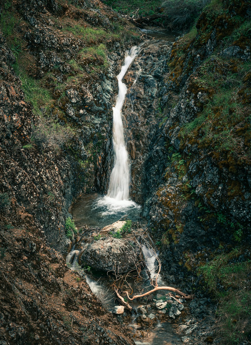 a small waterfall flowing down a rocky hillside