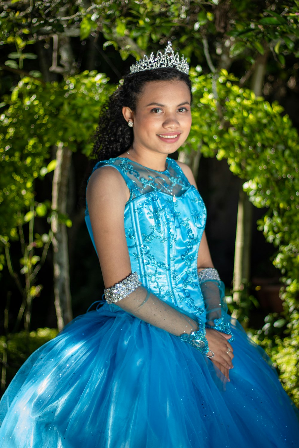 a young girl wearing a blue dress and a tiara