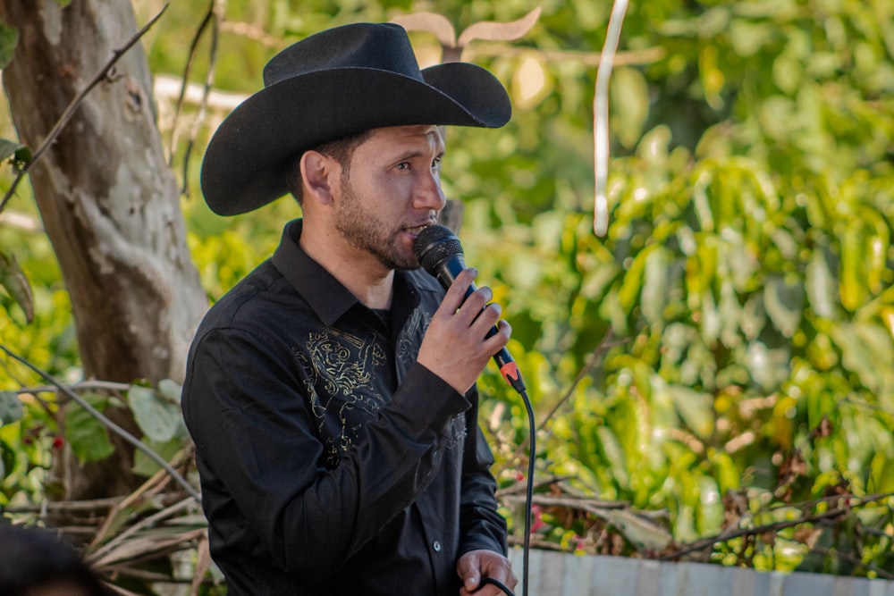a man in a cowboy hat holding a microphone