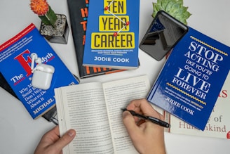 a person holding a pen and writing on a book
