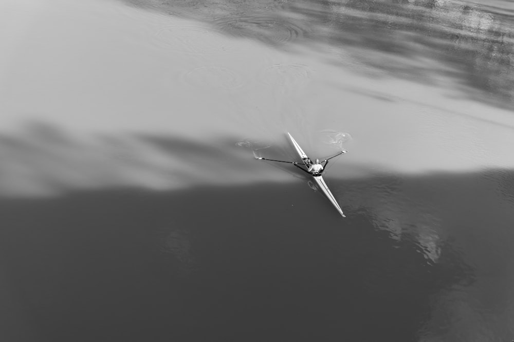 a single person rowing a boat on a body of water