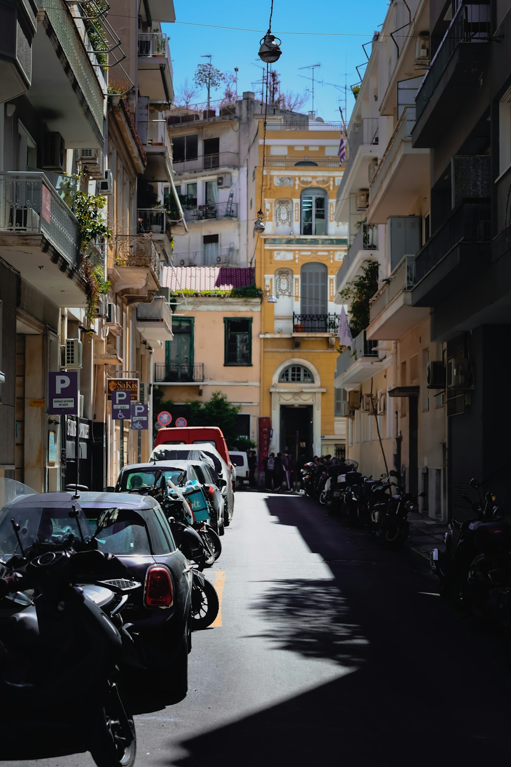 a street lined with parked cars and motorcycles