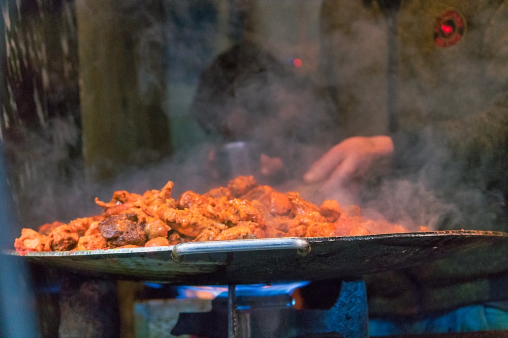 a person is cooking food on a grill