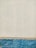 A textured wall with an upper portion painted in off-white and a lower portion in bright blue. The surface features visible brush strokes and signs of weathering. The separation between the colors is distinctly marked, suggesting a boundary between different materials or finishes.
