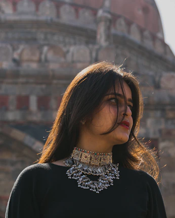 Depiction of a noble woman adorned with golden jewelry, gazing thoughtfully over the ancient city ruins.