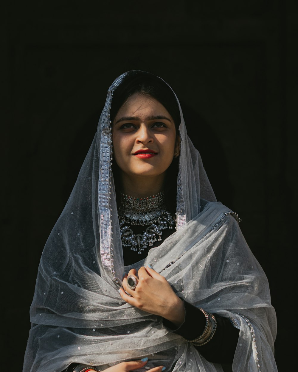 a woman wearing a veil and holding a purse