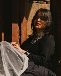 A serene portrait of Sandra Acosta seated in a sunlit room surrounded by mandalas and healing crystals.