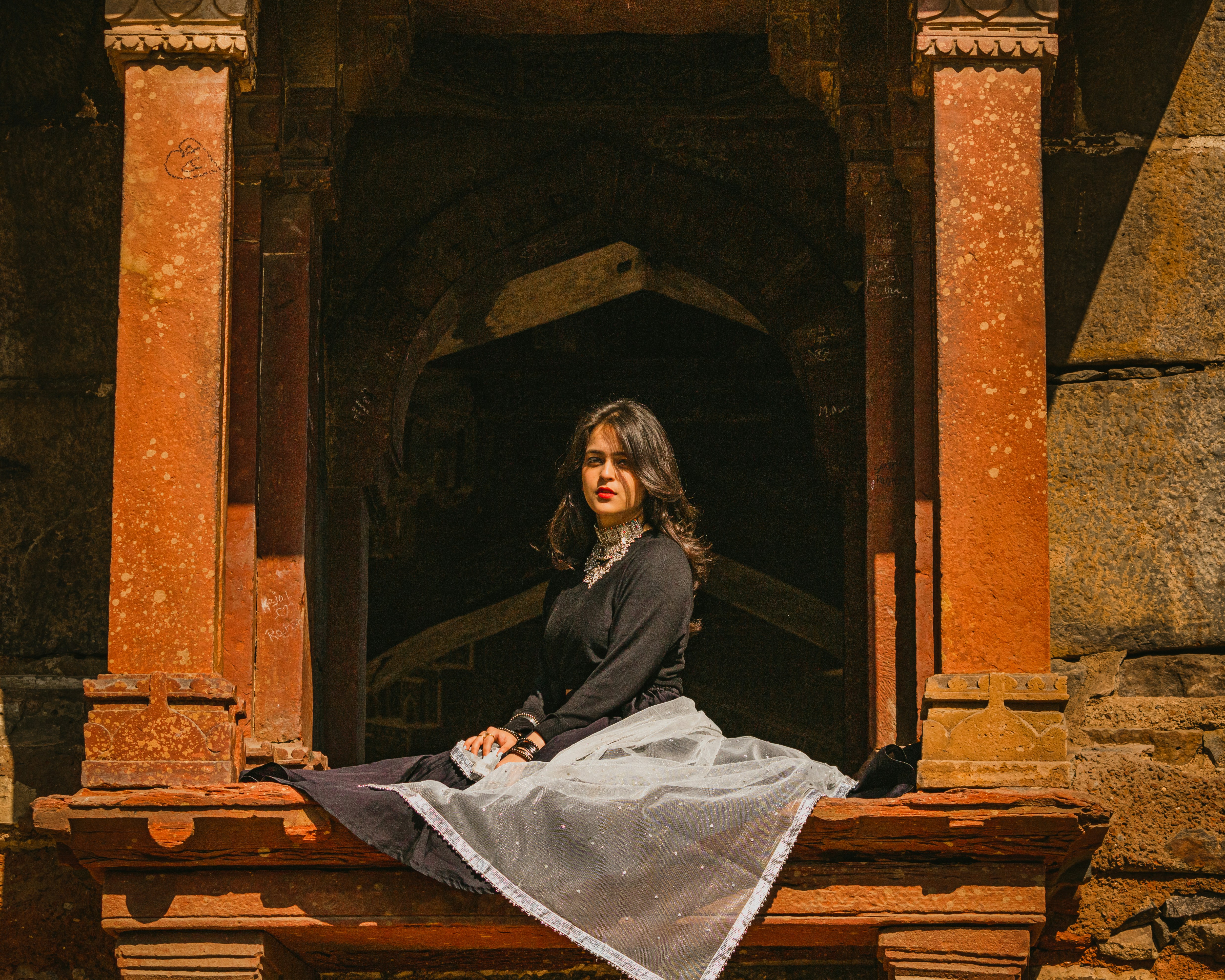 a woman sitting on a wooden bench in a building