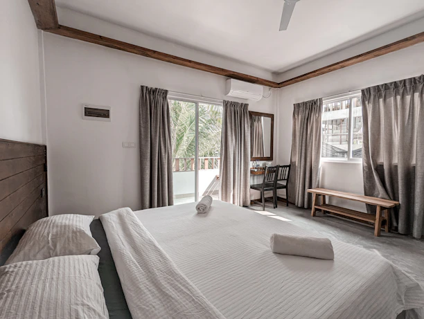 Comfortable bedroom featuring soft linens, air conditioning unit, and a sleek minimalist design.