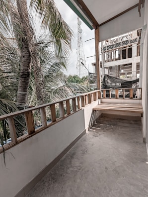 Workers carefully measuring and preparing the balcony surface for decking installation.