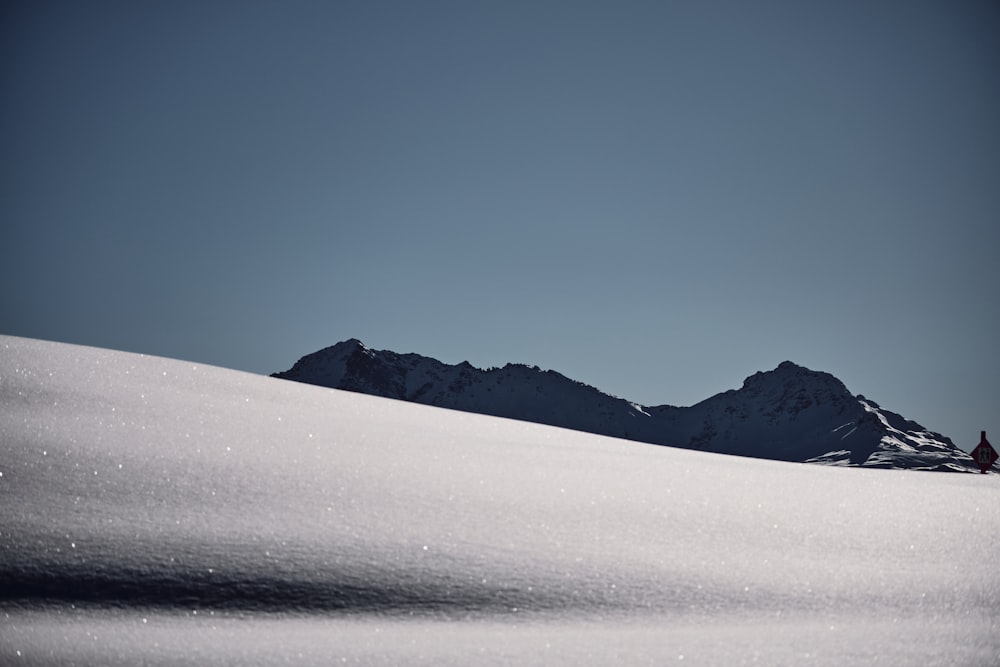 a person riding a snowboard down a snow covered slope