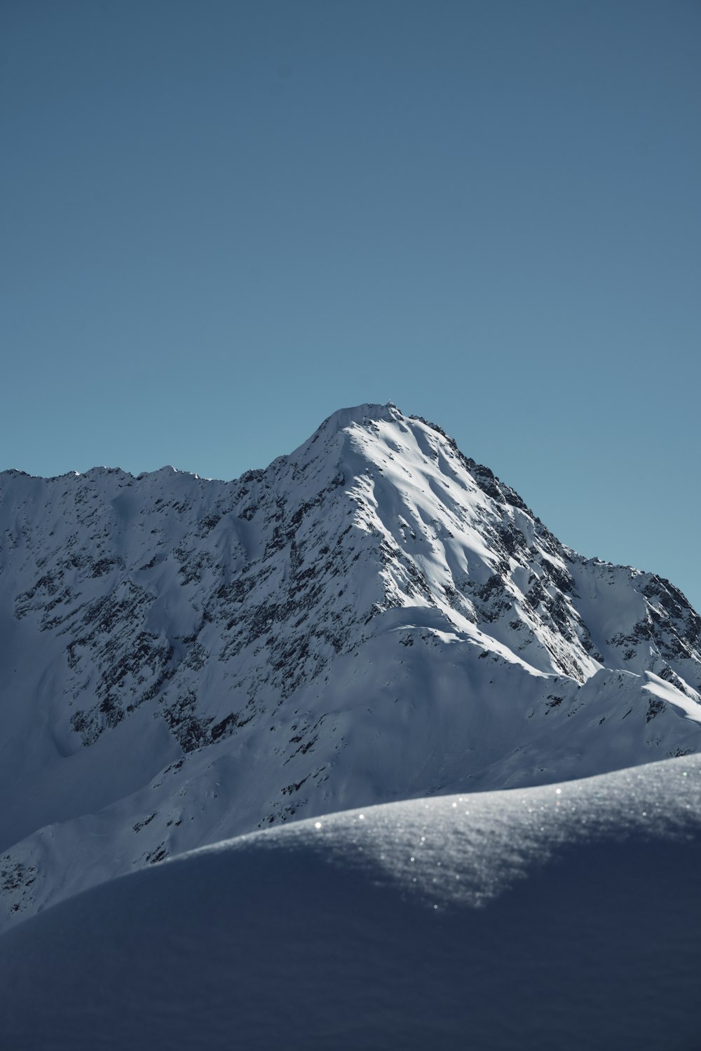 a mountain covered in snow under a blue sky