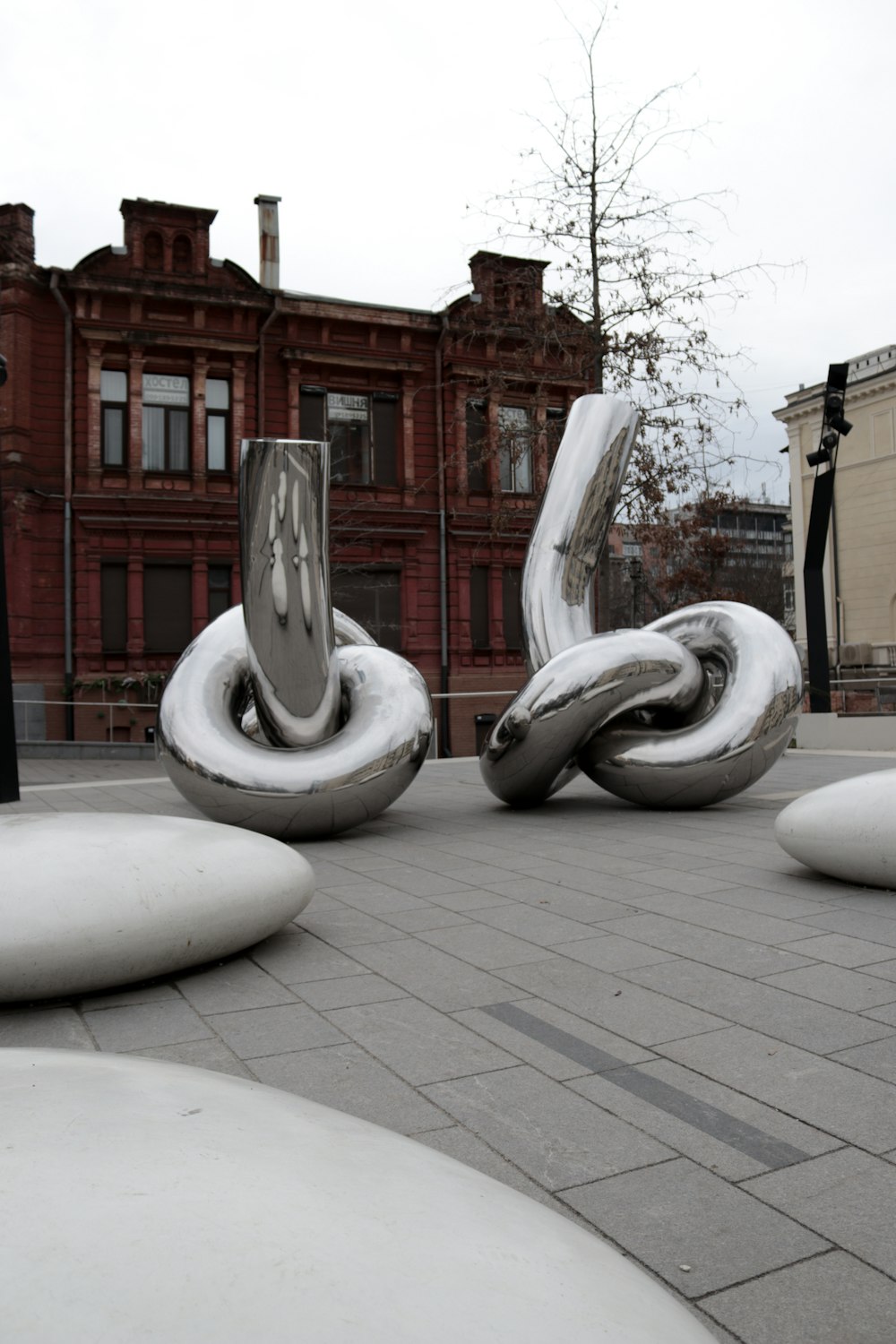 歩道の上に座っているいくつかの大きな金属彫刻