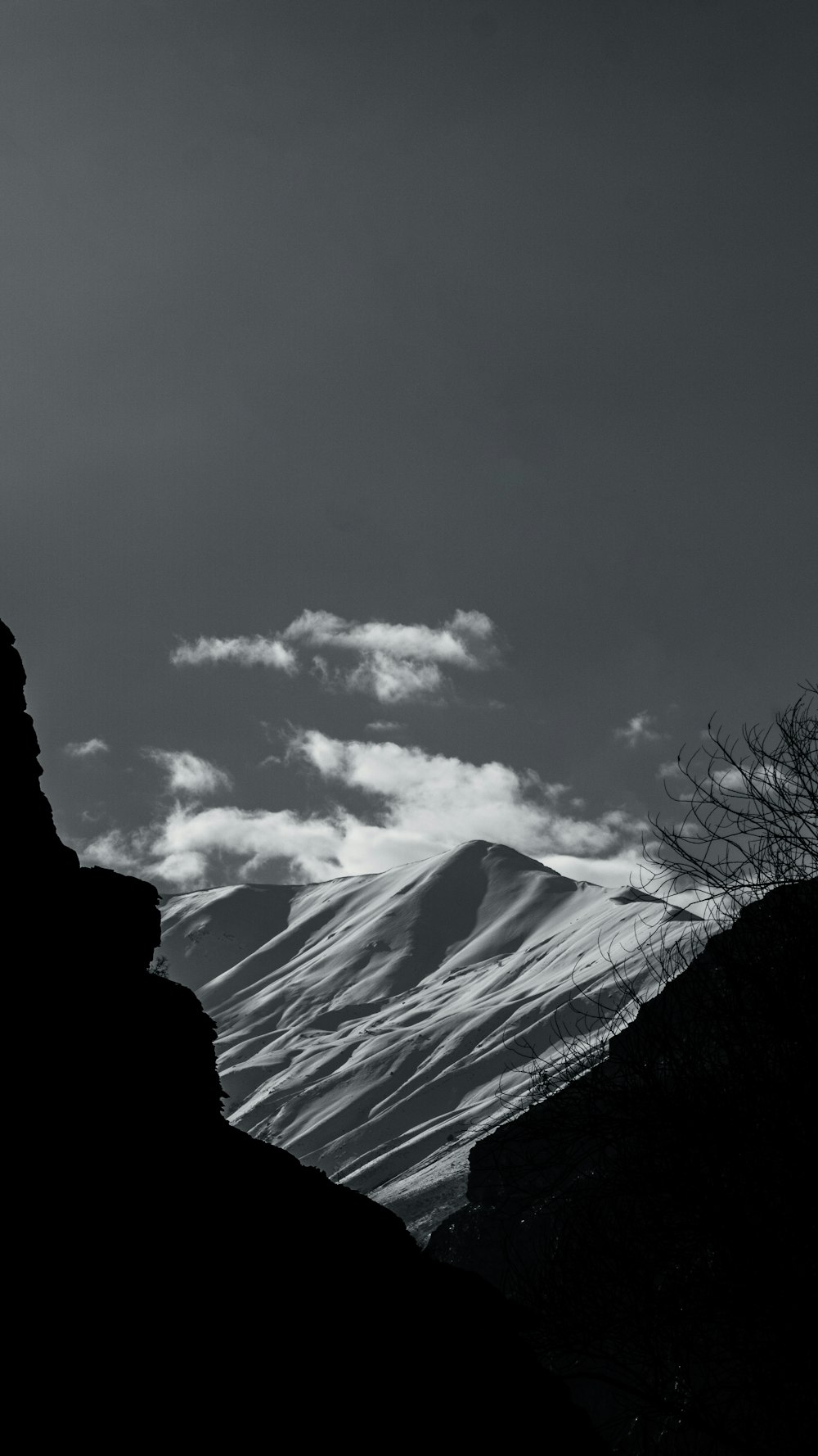 a black and white photo of a person standing on top of a mountain