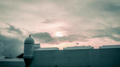 Warm photograph of the Baluarte de Santiago at sunset with soft golden light.