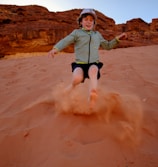 a young child is running in the sand