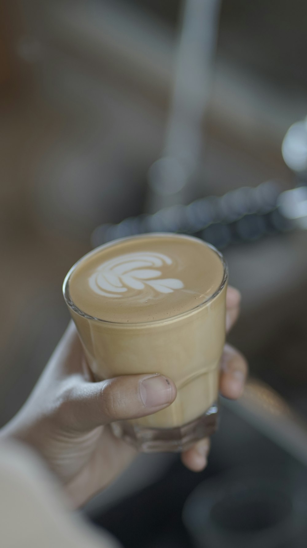 a person holding a cup of coffee in their hand