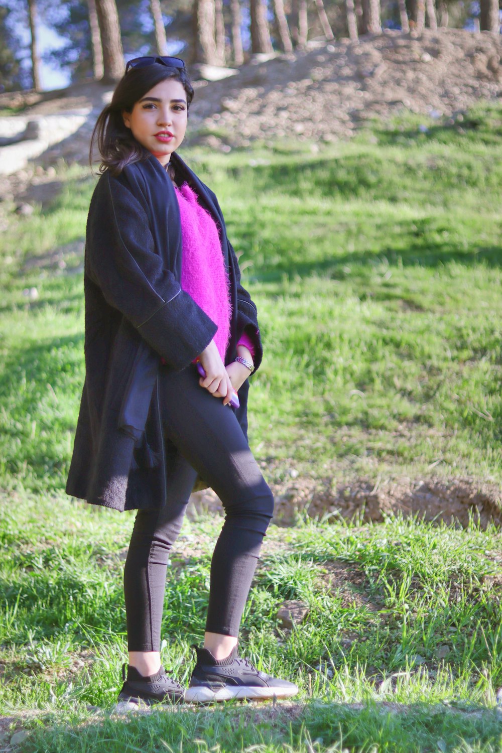 a woman in a black coat and a pink scarf