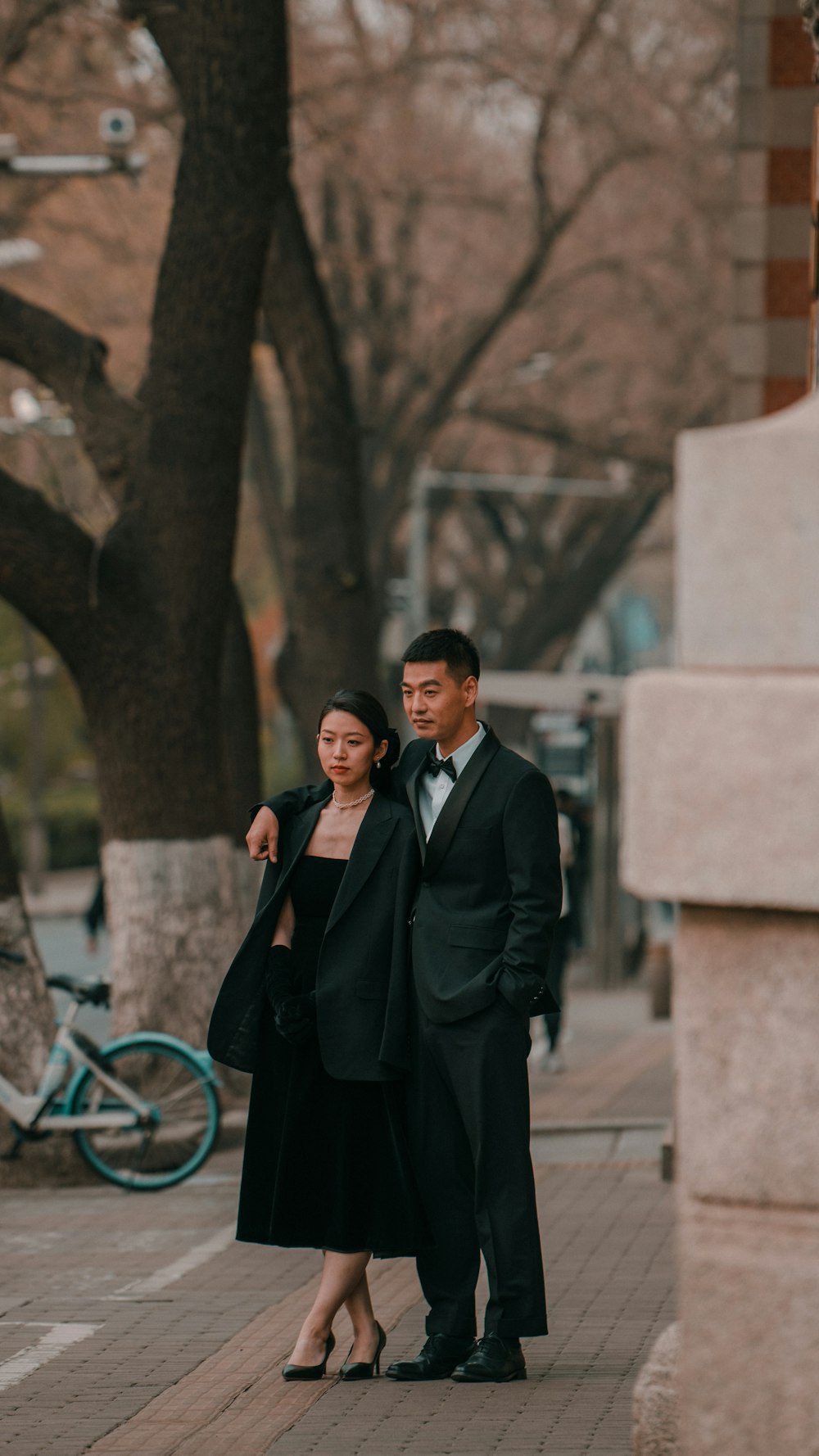 a man and a woman standing next to each other on a sidewalk
