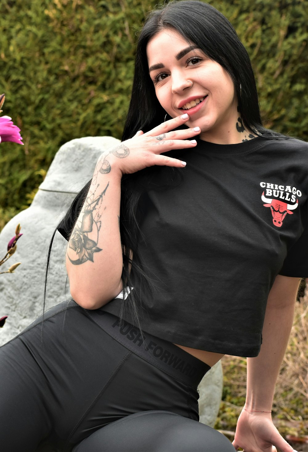 a woman sitting on a rock posing for a picture