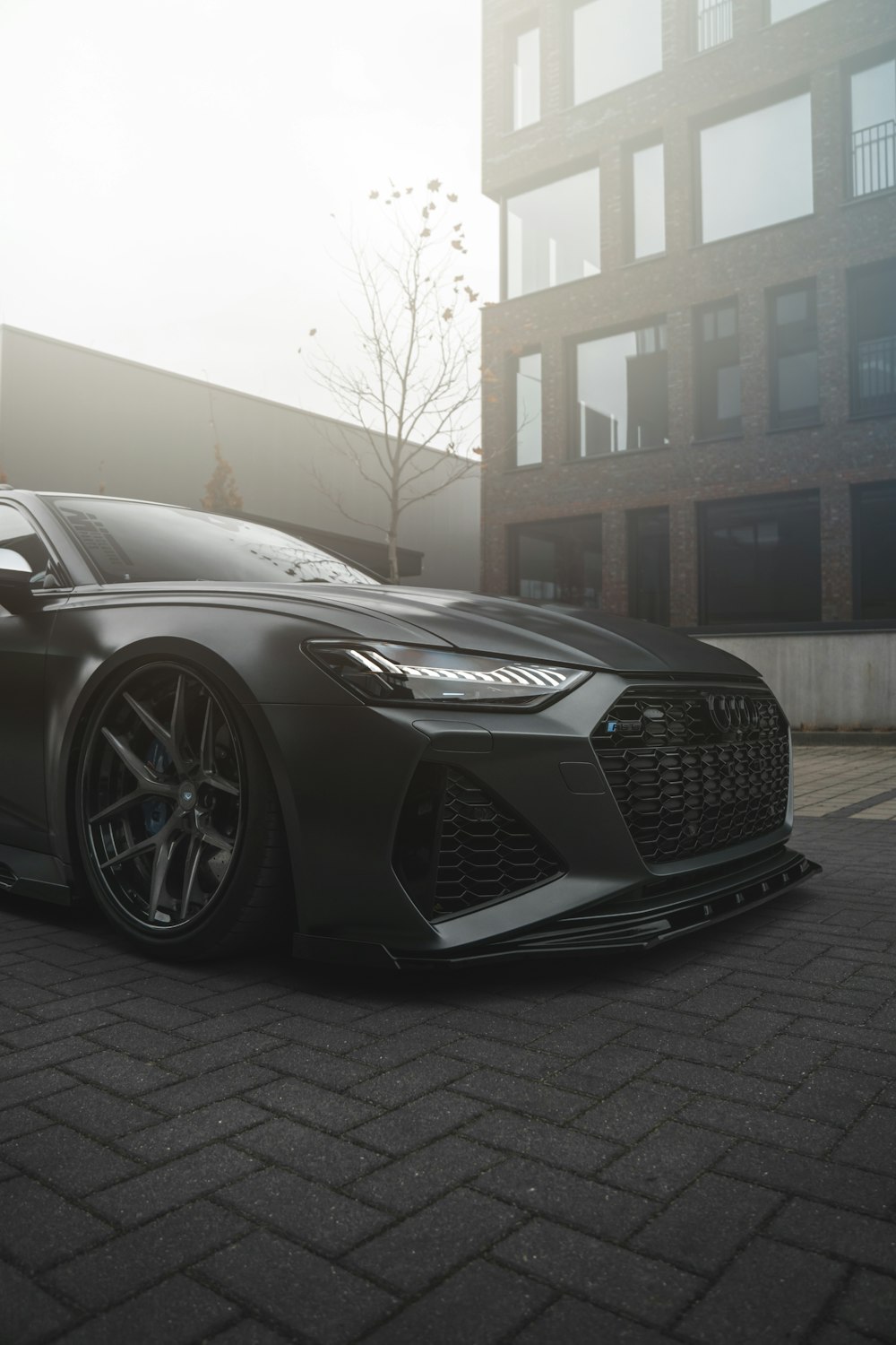 a grey sports car parked in front of a building