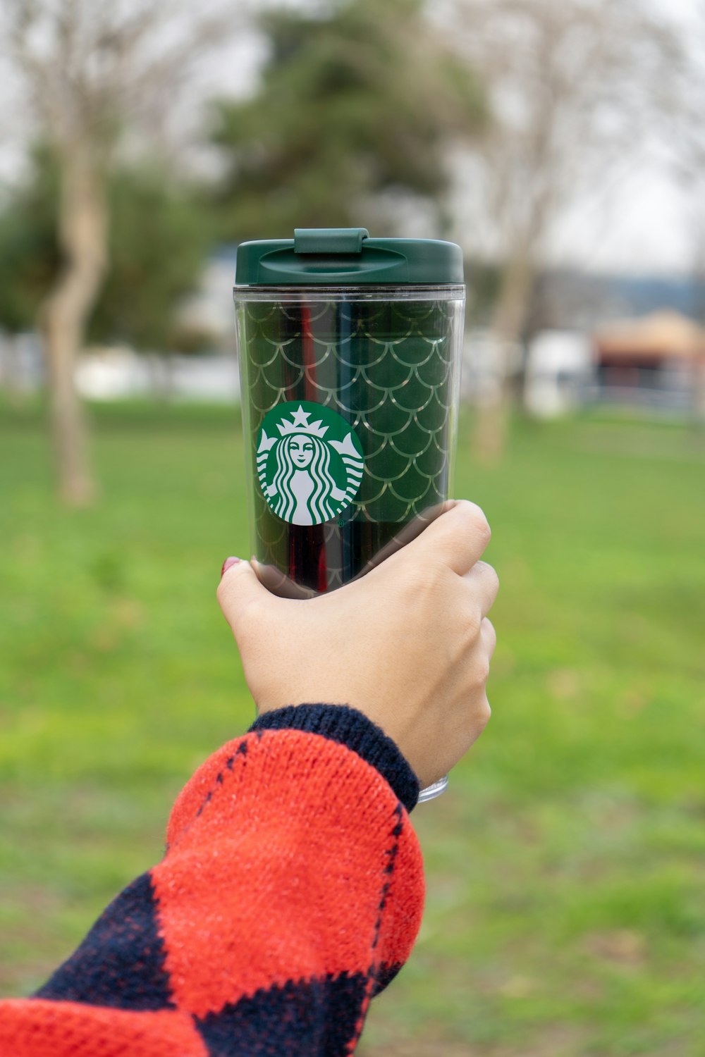 a person holding a starbucks cup in their hand