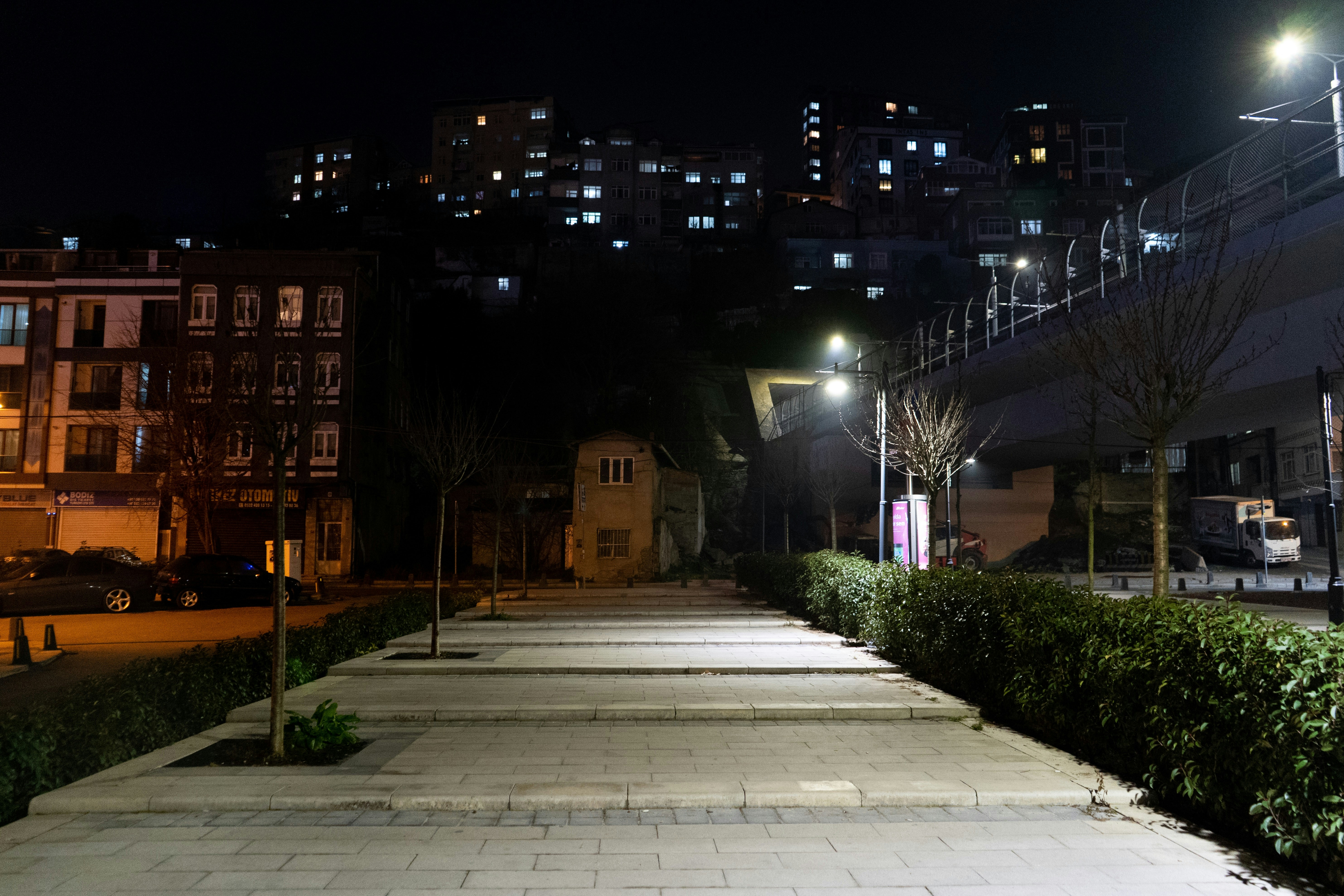 a city street at night with a few buildings in the background - a-city-street-at-night-with-a-few-buildings-in-the-background-TrghoTI9z18