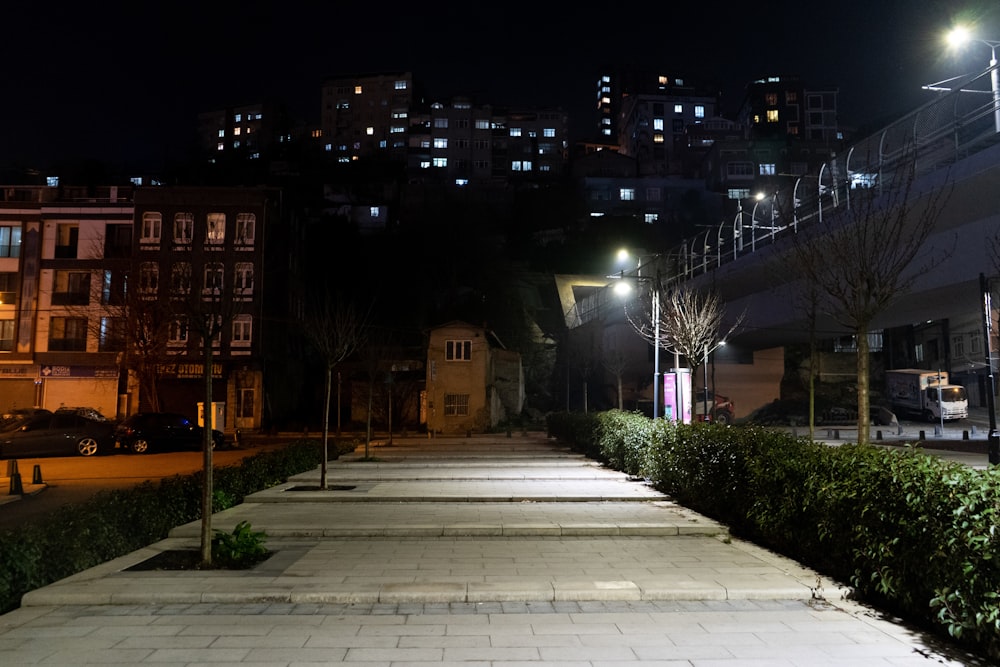 Eine Stadtstraße bei Nacht mit ein paar Gebäuden im Hintergrund