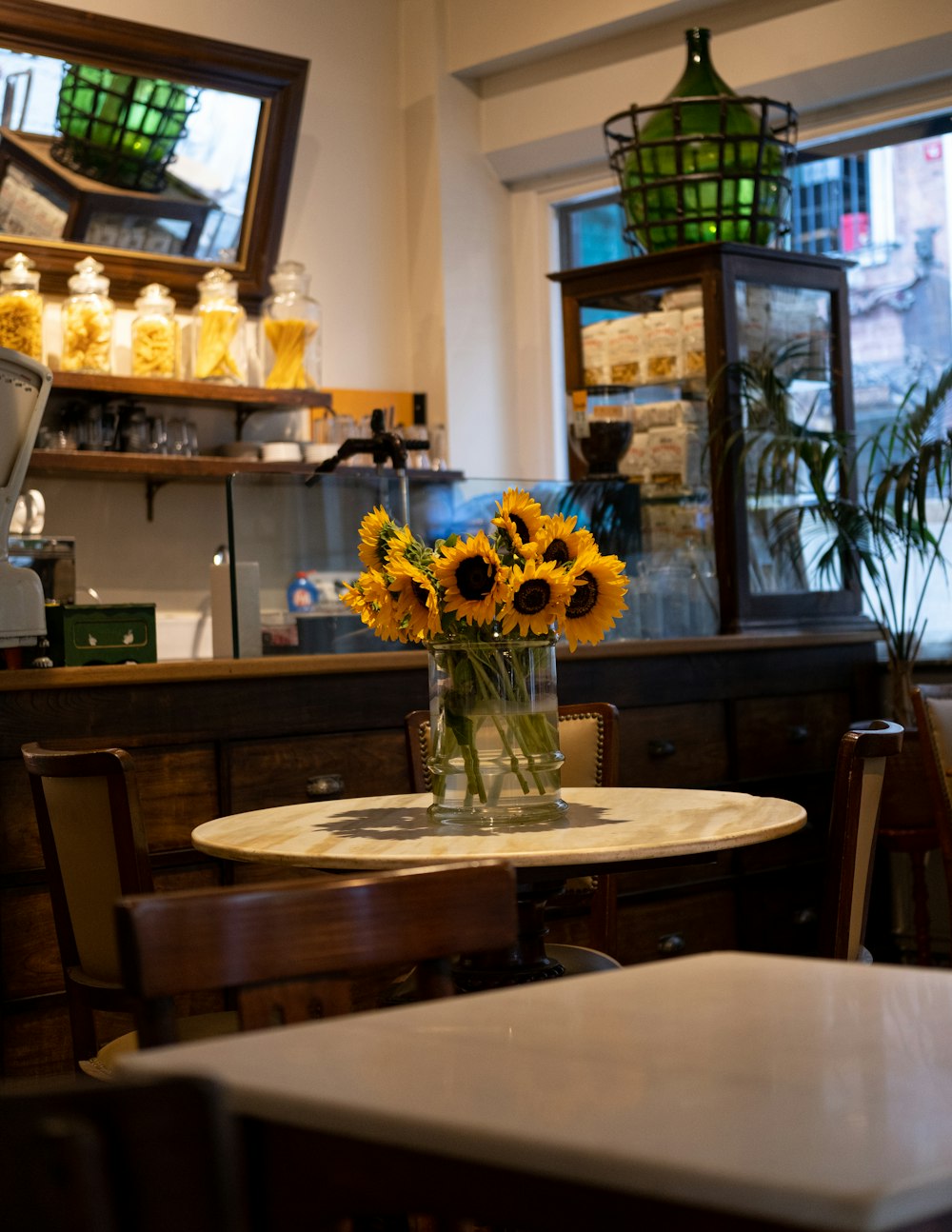 a table with a vase of sunflowers on it