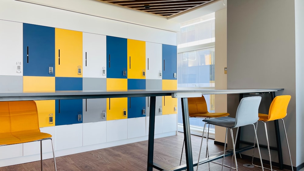 a room with a table, chairs, and lockers