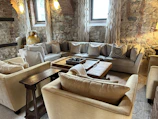 Wide shot of a cozy living room featuring exposed brick walls and warm lighting.