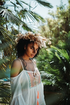 a woman standing in front of a palm tree