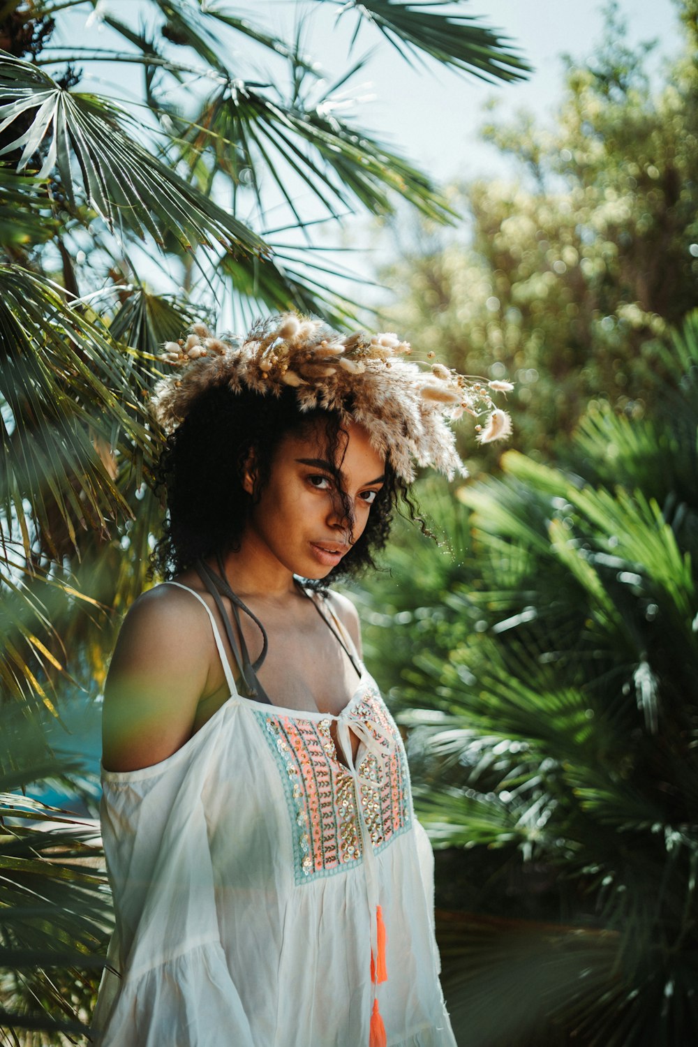 a woman standing in front of a palm tree