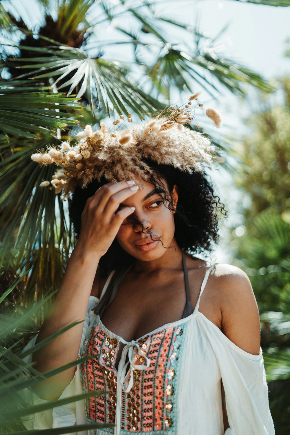 a woman in a white top is holding her head