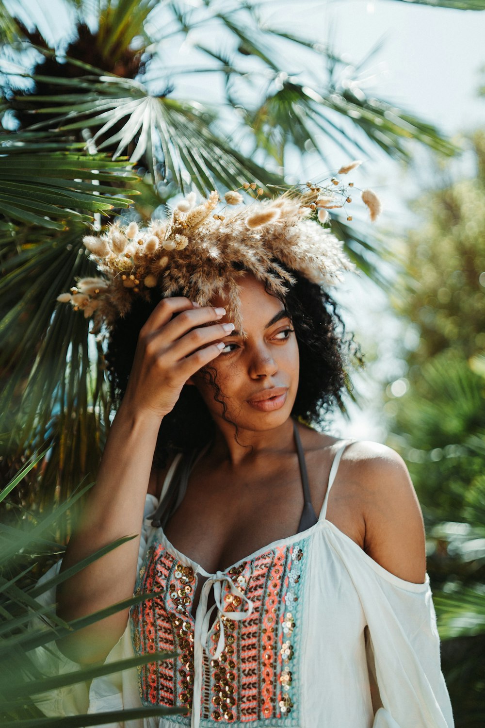 a woman in a white top with a flower crown on her head