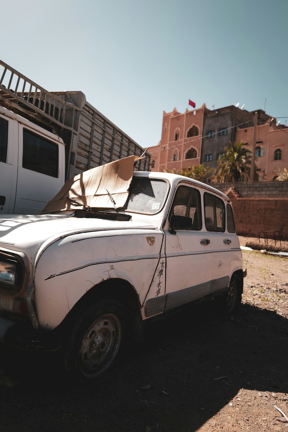 an old white car parked in front of a building