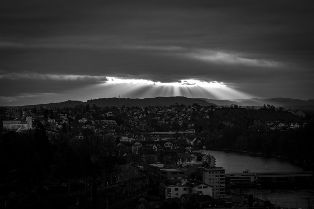 uma foto em preto e branco do sol brilhando através das nuvens