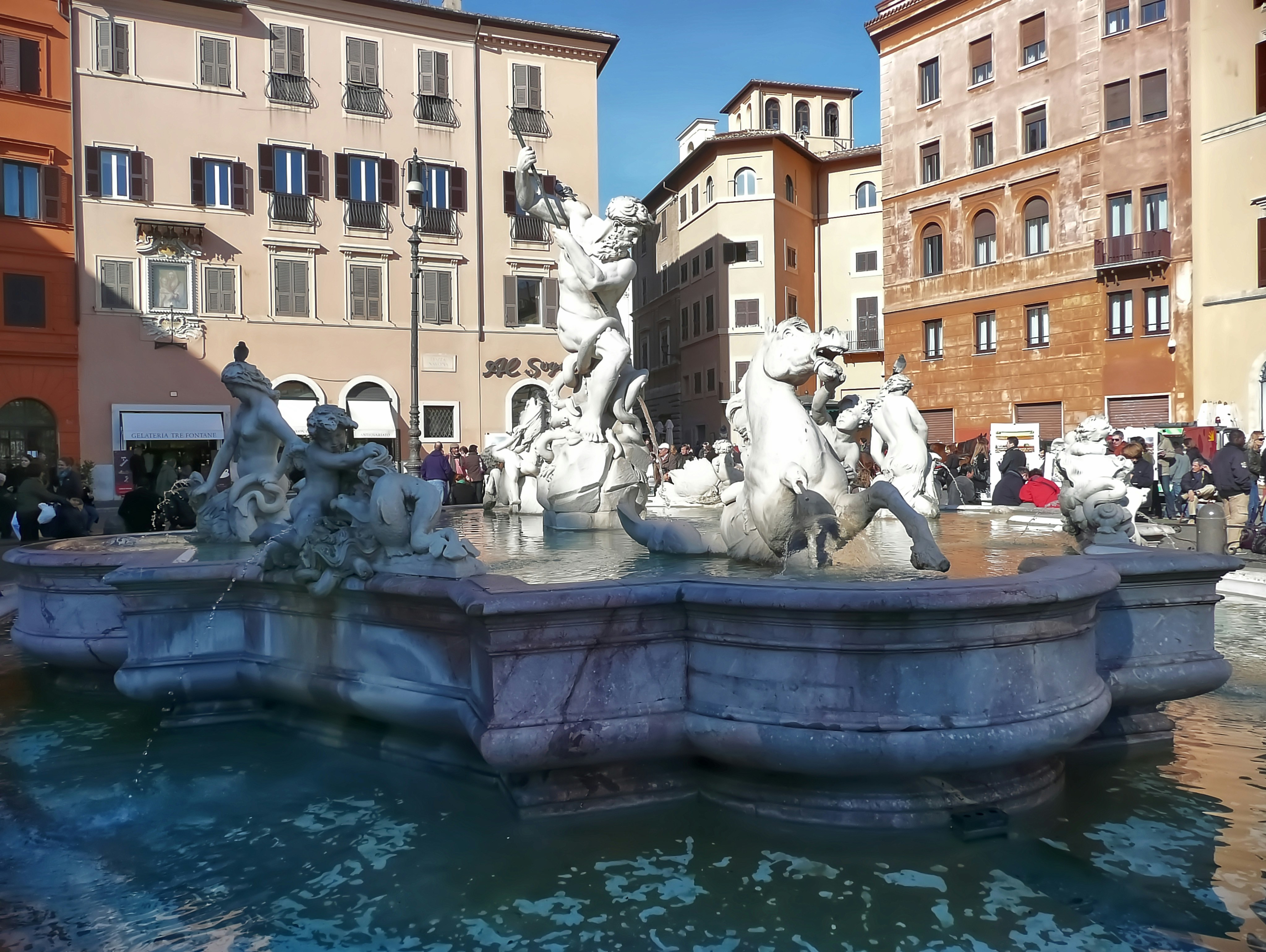 a group of people standing around a fountain