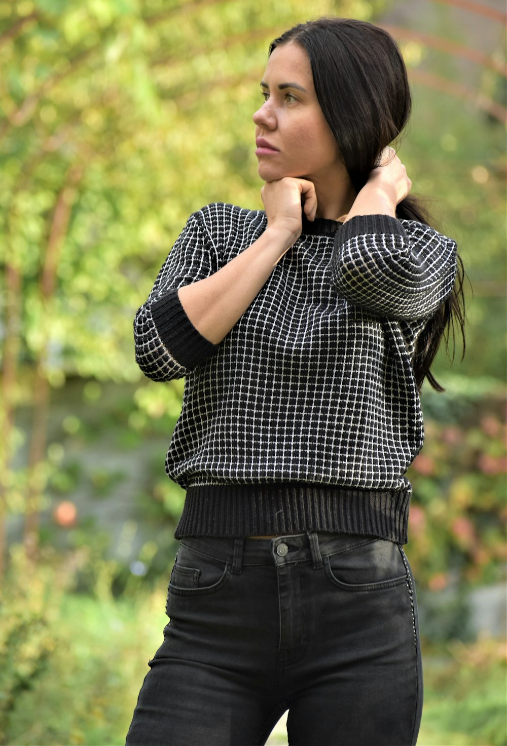 a woman in a black and white shirt and jeans