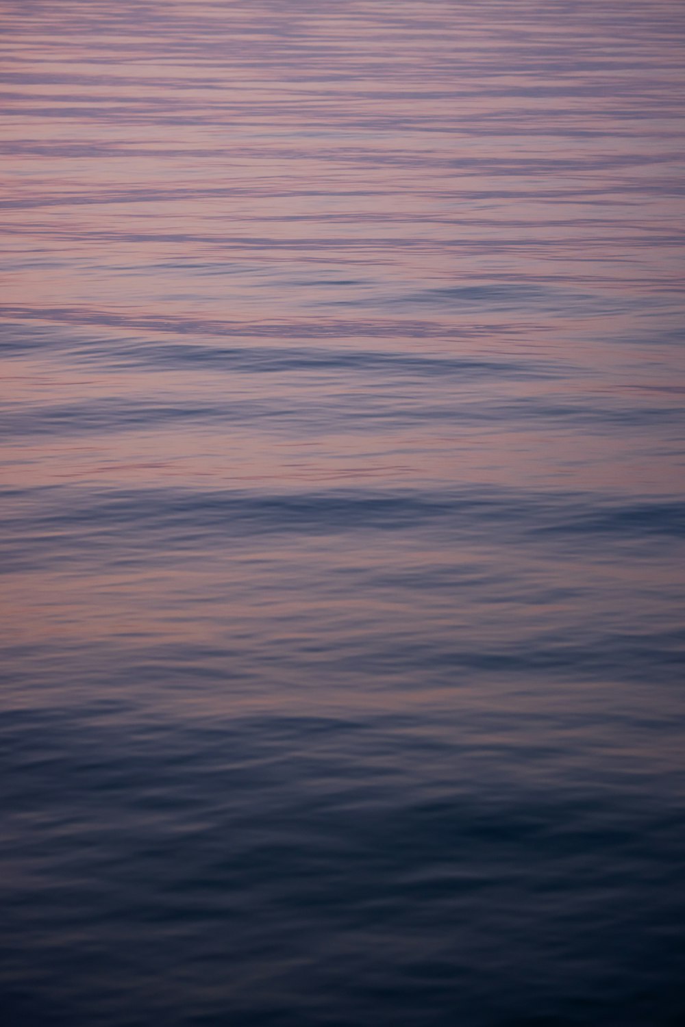 a large body of water with a boat in the distance