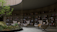 A serene library space with curved bookshelves filled with books, surrounding a central green atrium featuring a rock formation and small plants. Comfortable, modern armchairs with side tables are arranged around the atrium, inviting relaxation and reading.