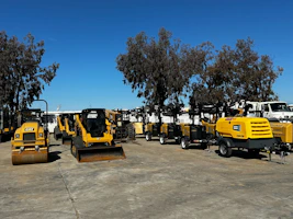 Heavy construction machinery parts stacked neatly in a warehouse.
